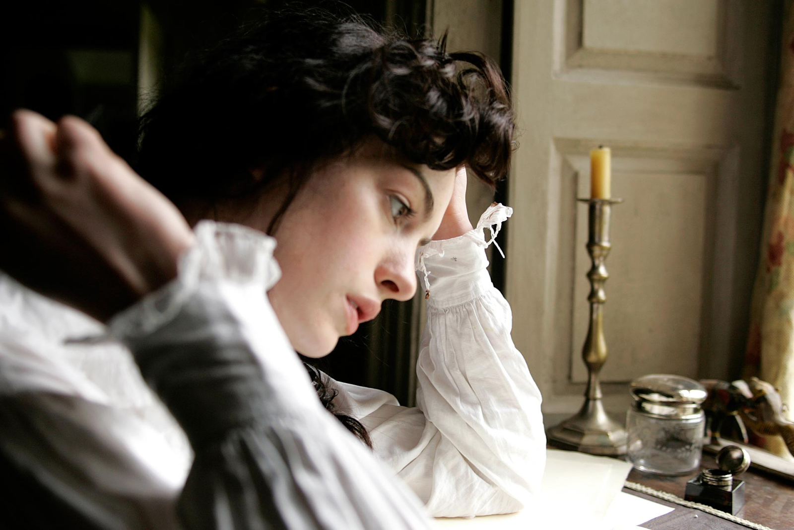 Jane Austen (Anne Hathaway) observa afligida sus borradores y escritos.