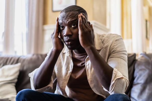 shot of a young man looking stressed out at home - black man  stock pictures, royalty-free photos & images