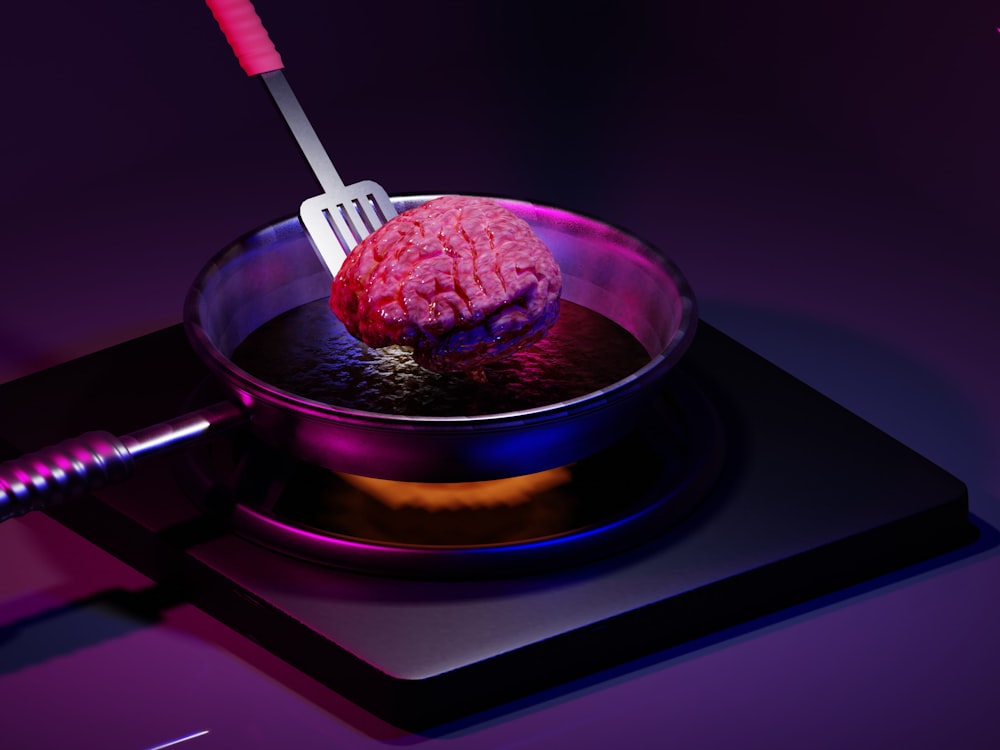 a pink brain in a bowl with a fork in it