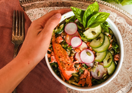 Meal bowl with cucumber, sunflower seeds, seasoned trout, salad, basil.