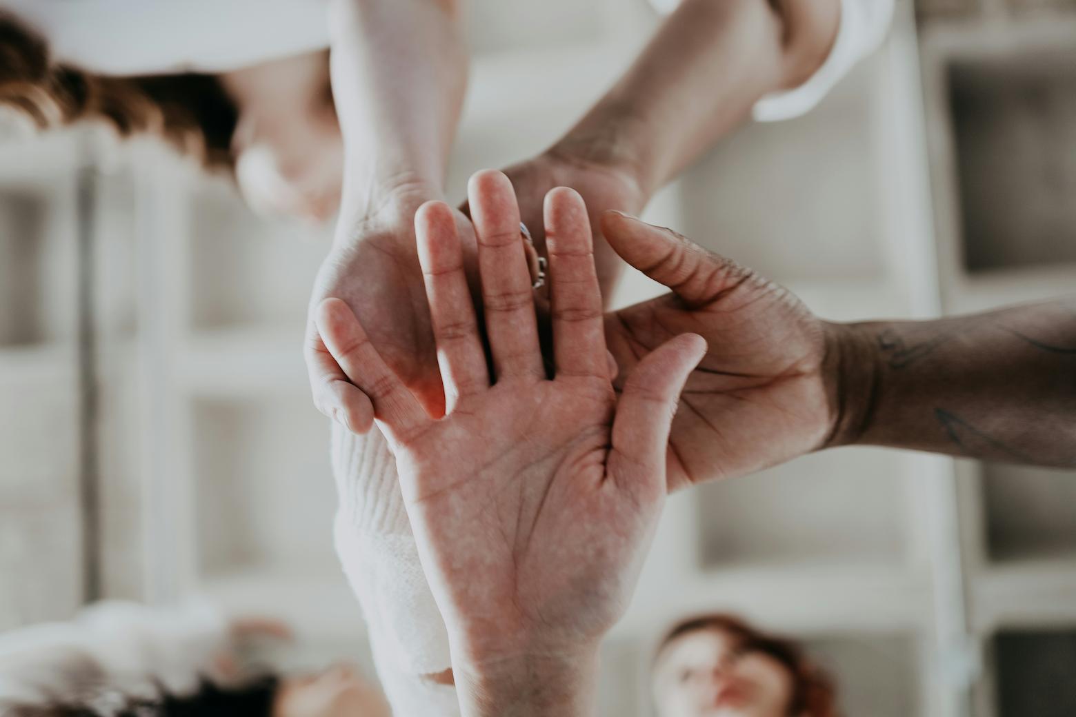 Hands on top of each other, showing the unity of different races.