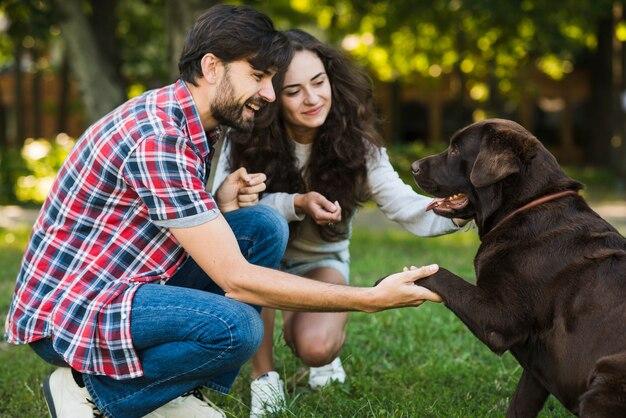 Beautiful couple loving their dog in park