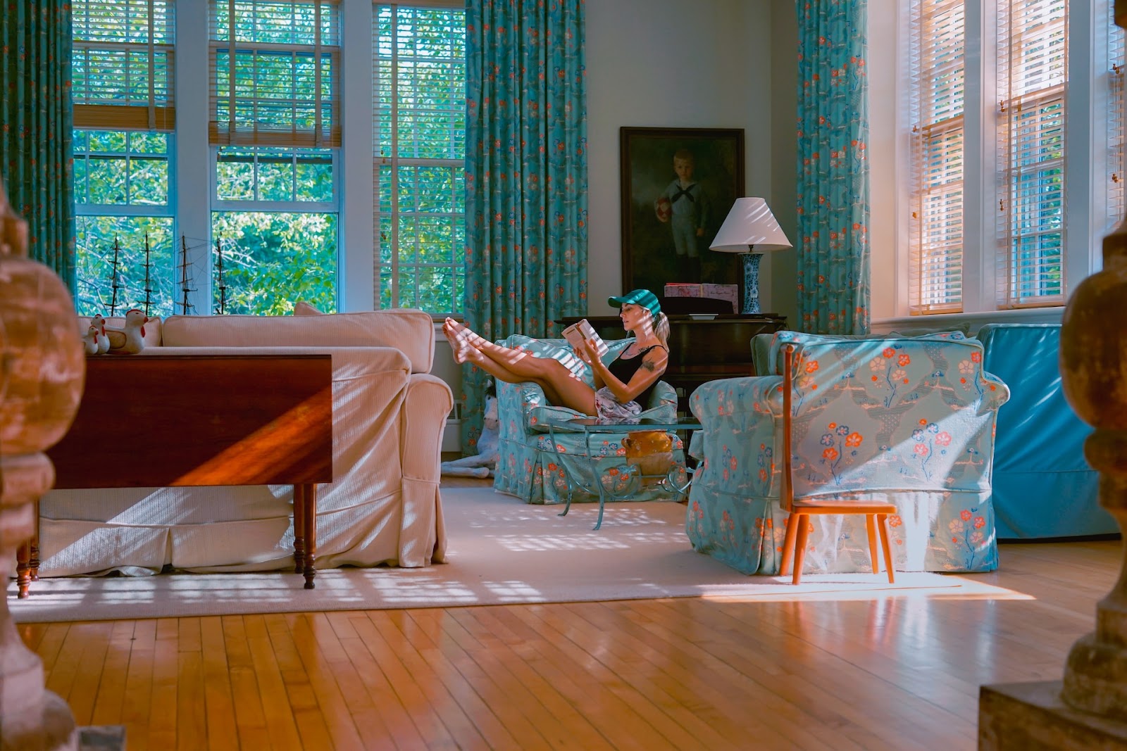 woman reading on a chair with matching patterns on chair and curtains