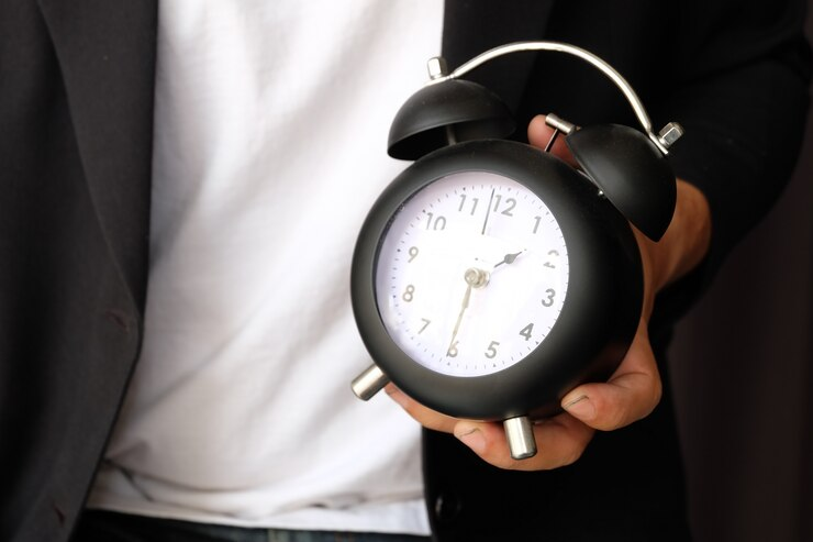 Law student holding clock, symbolising time management in law.