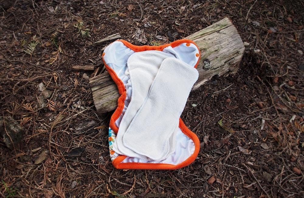 an orange and white cloth on a piece of wood