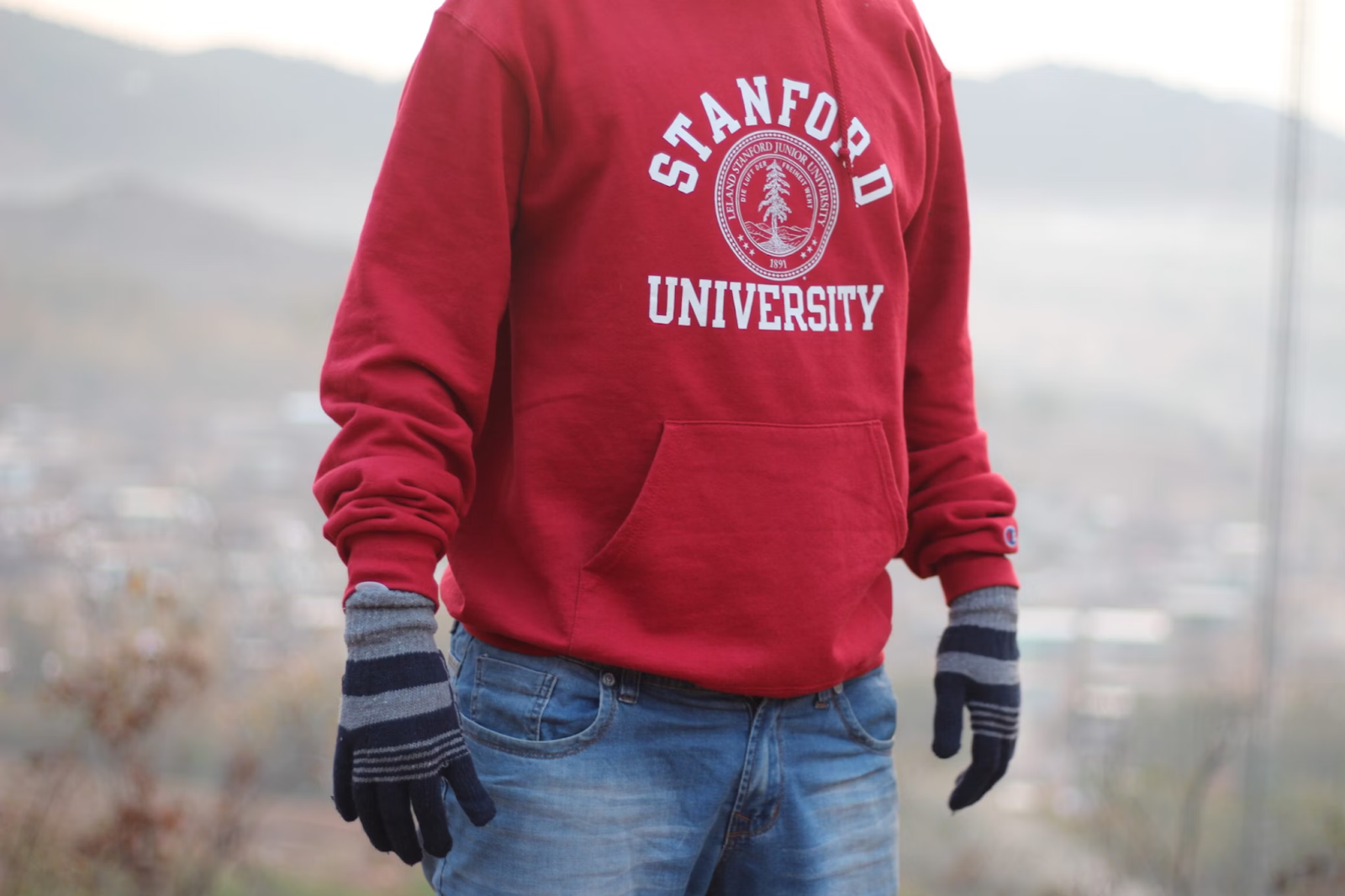 Person wearing custom sweatshirt with university logo on the front
