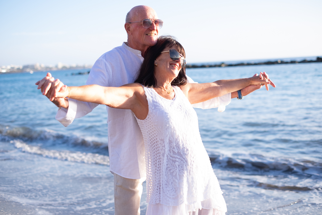 Seniors on beach holding hands