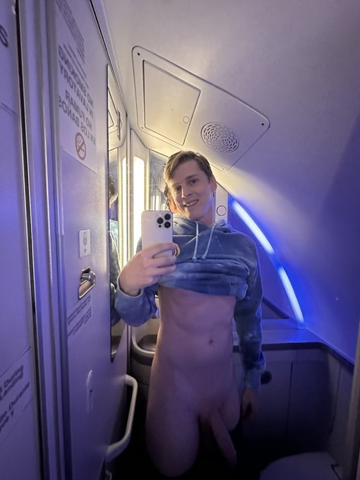Sage Roux with his pants pulled down and his semi erect cock visible while taking an airplane lavatory selfie and lifting up his hoodie