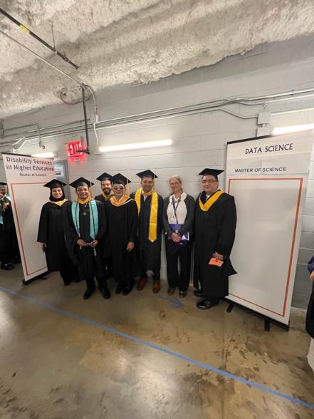 A group of people in graduation gowns and caps

Description automatically generated