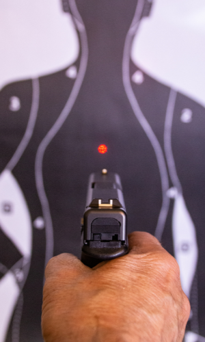 handgun using a laser sight pointed at the chest of a paper target