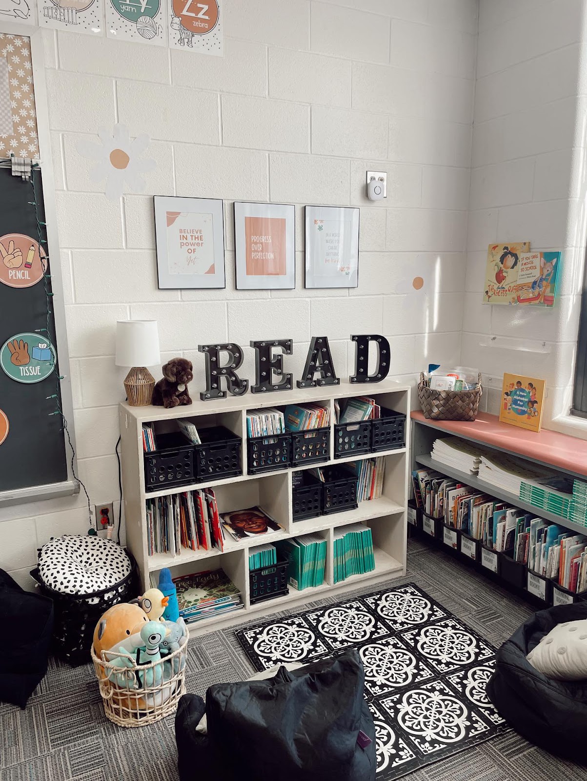 This image shows a reading corner in a classroom with bean bag chairs, a rug, and a basket of stuffed animals. 