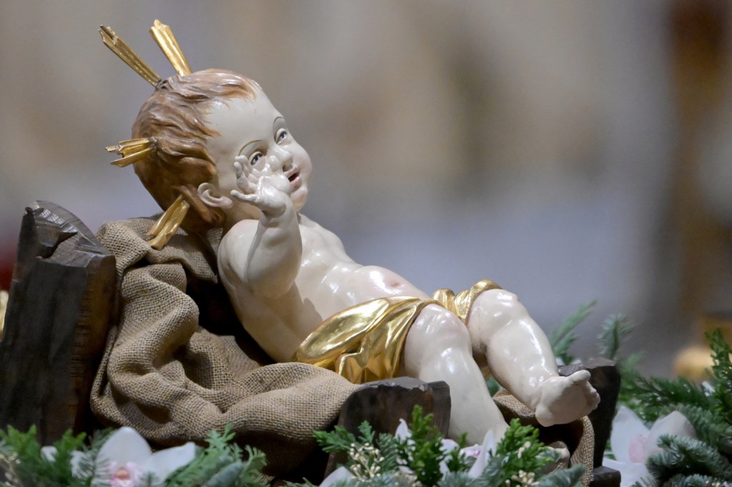A picture shows a figurine of the baby Jesus during the Christmas Eve mass at St. Peter's Basilica in the Vatican on December 24 2023