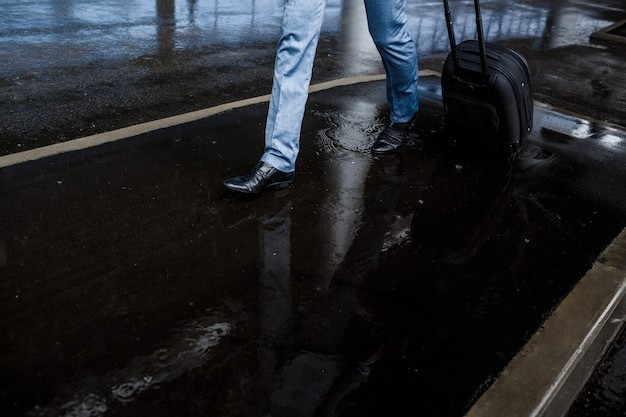 Businessman holding  suitcase walking in rain