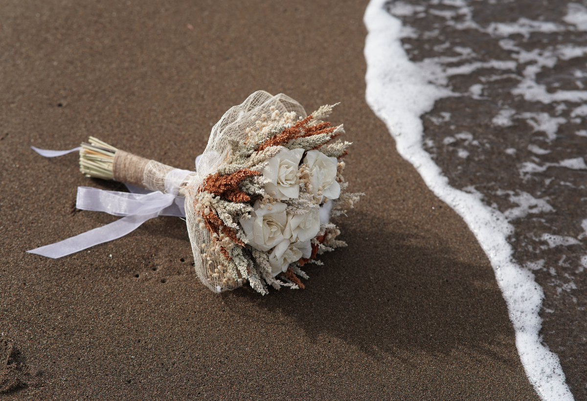 A bouquet of flowers on the beach

Description automatically generated