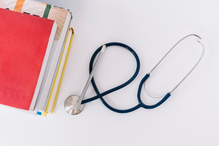 Stacked books and stethoscope - Medicine Summer School essentials.