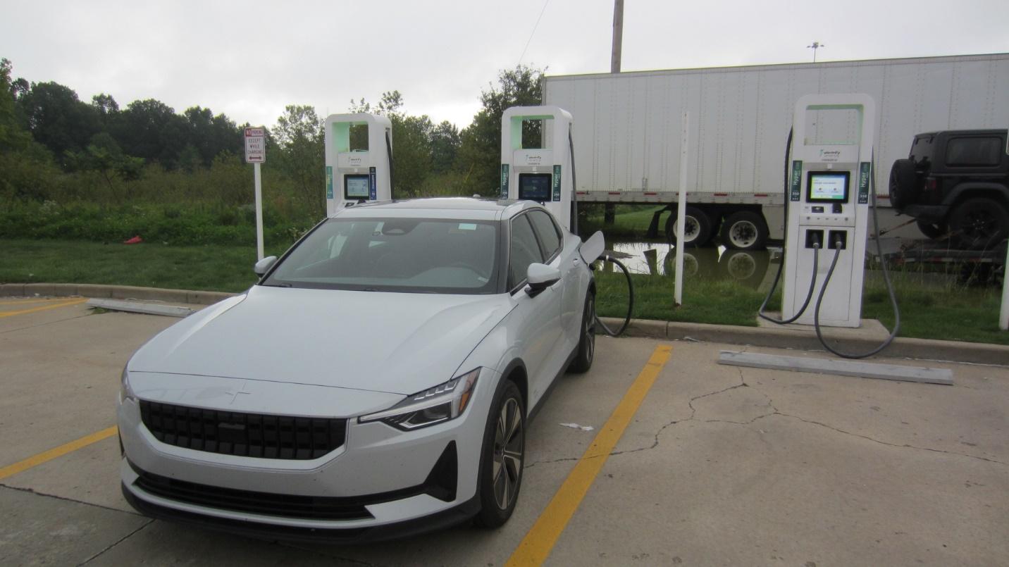 A white car at a charging station

Description automatically generated