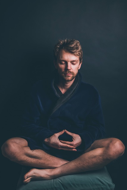 Man sitting in his robe meditating  and relaxing and enjoying Benefits of an Ayurvedic Cleanse.
