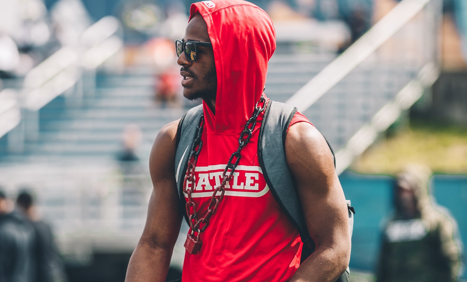 Football player wearing the Battle Sleeveless Light Action Hoodie to showcase muscular arms during football training