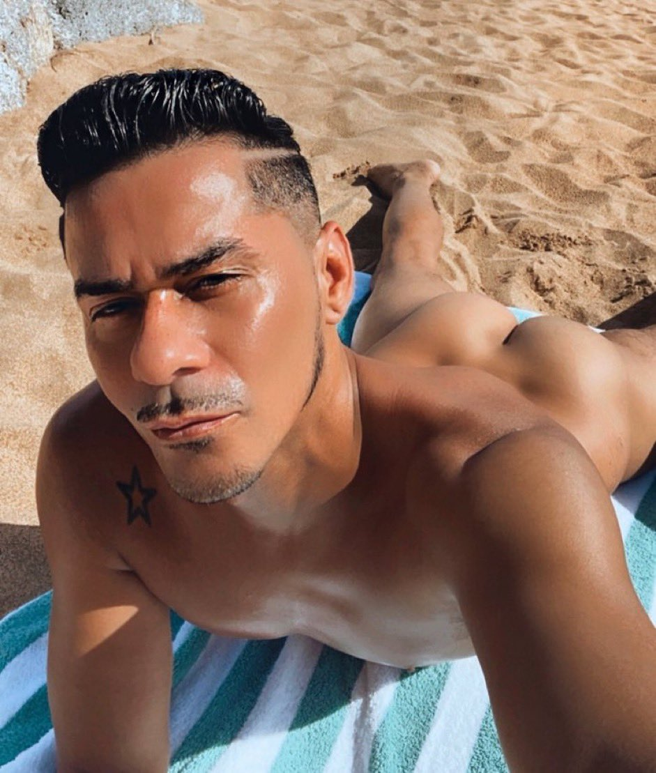 Cesar Xes naked at the beach lying on a towel showing his shaved toned butt