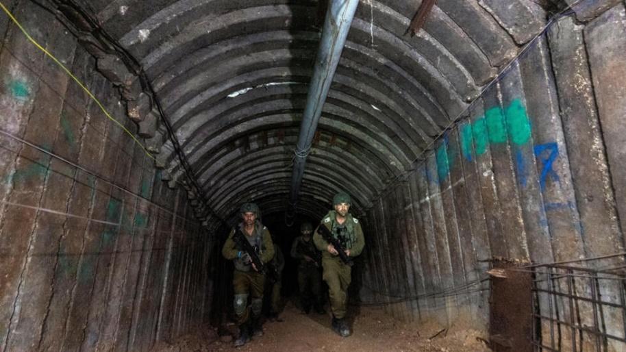 Sur cette photo prise lors d'une tournée médiatique organisée par l'armée israélienne le 15 décembre 2023, des soldats visitent un tunnel que le Hamas aurait utilisé pour attaquer Israël via le poste 