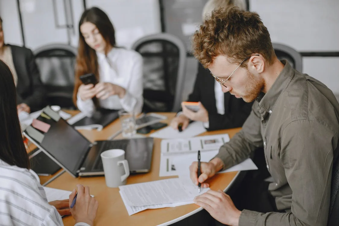 man signing a document at an office