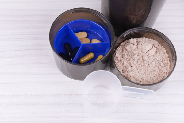 A cup of capsules and protein powder