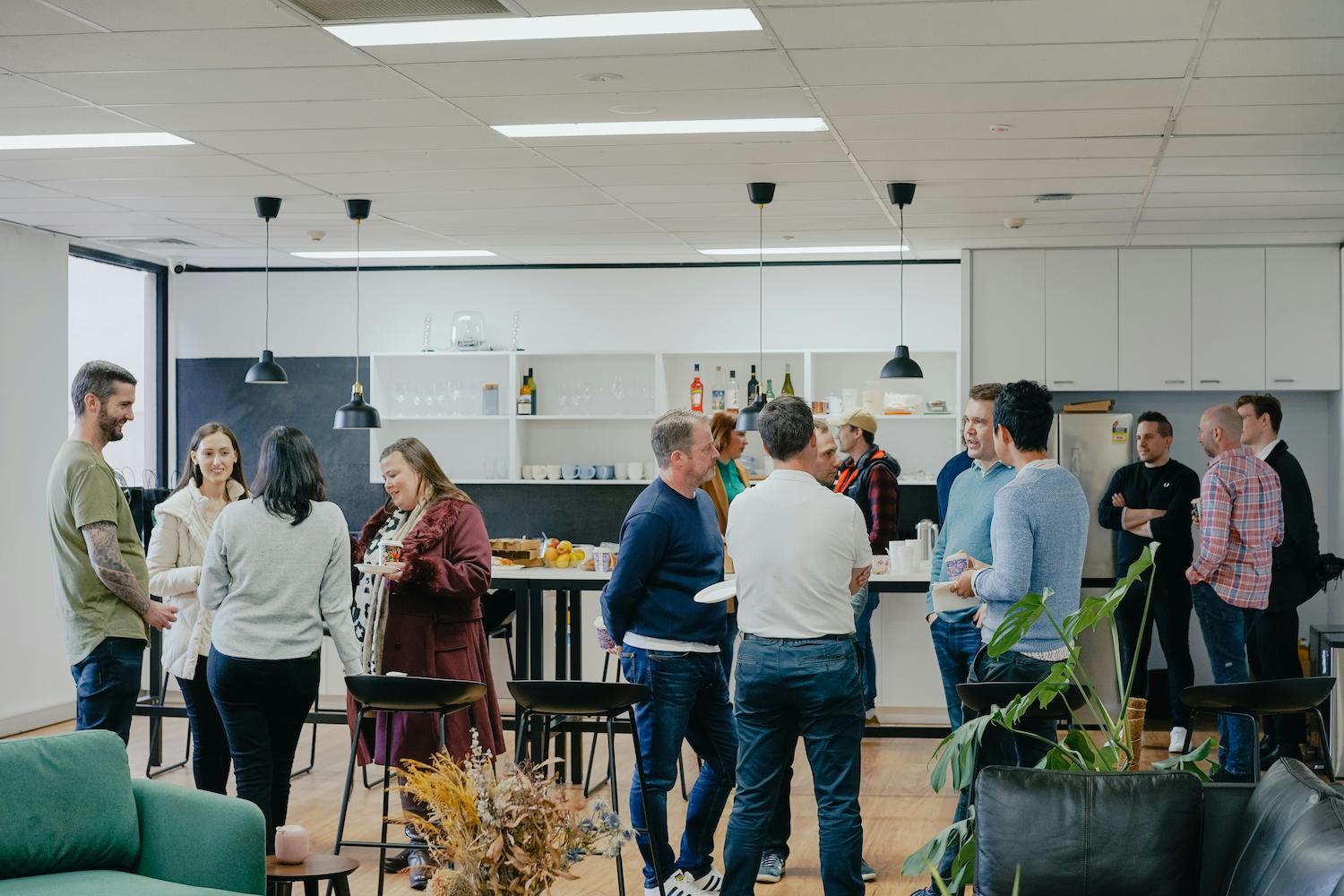 Employees engaging with each other, having conversations in several groups. Employee engagement is one of the topics business keynote speakers discuss.