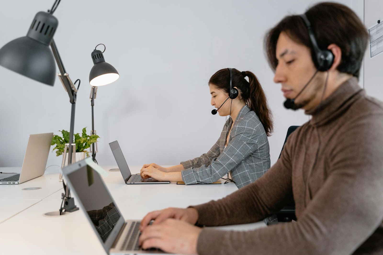 Two people working as virtual personal assistants on their computer