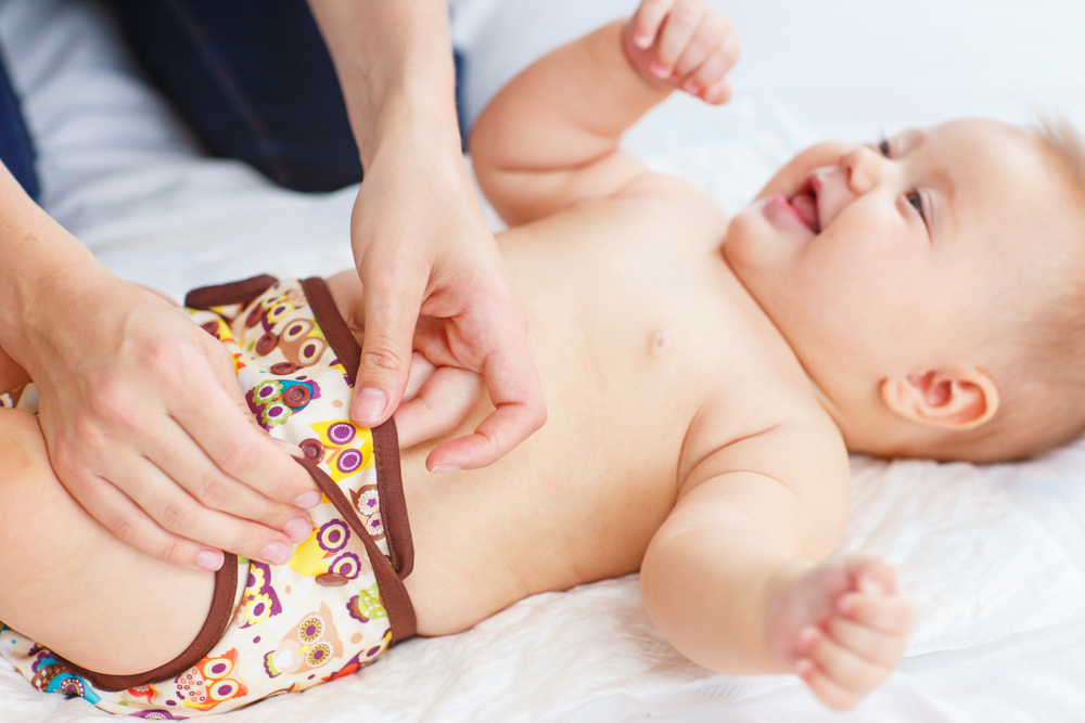 a happy baby wearing cloth diaper 