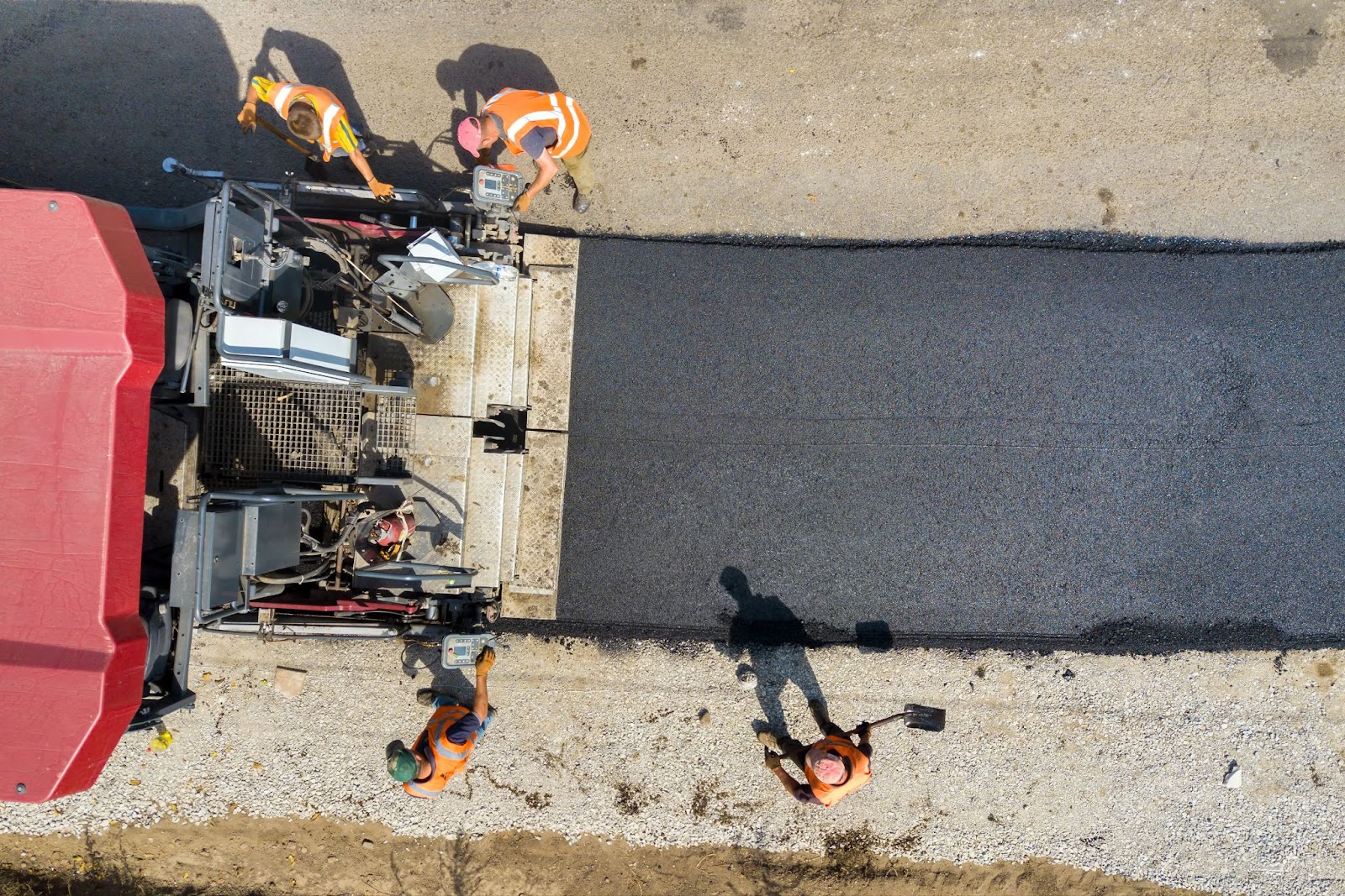 Construction workers paving asphalt. 