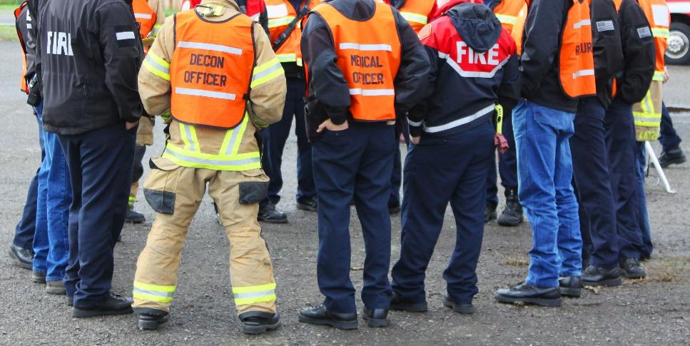 A group of people in orange vests

Description automatically generated