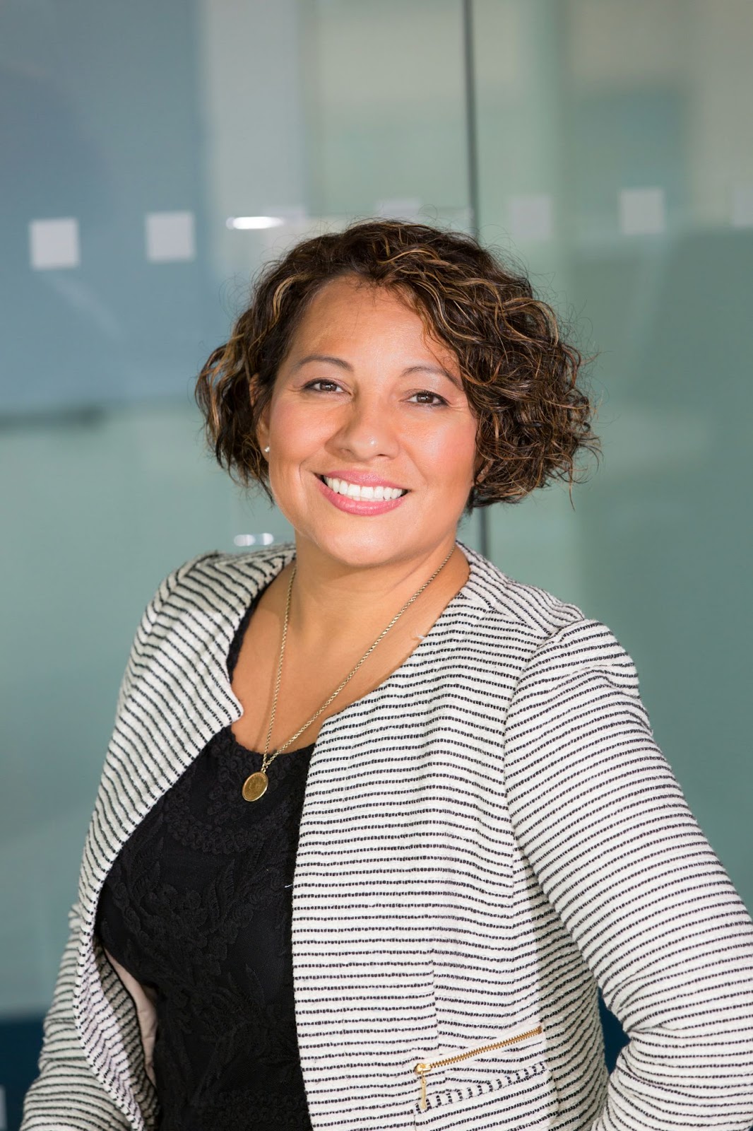 A woman posing for her professional headshot while slightly tilting to her side to show her best angle