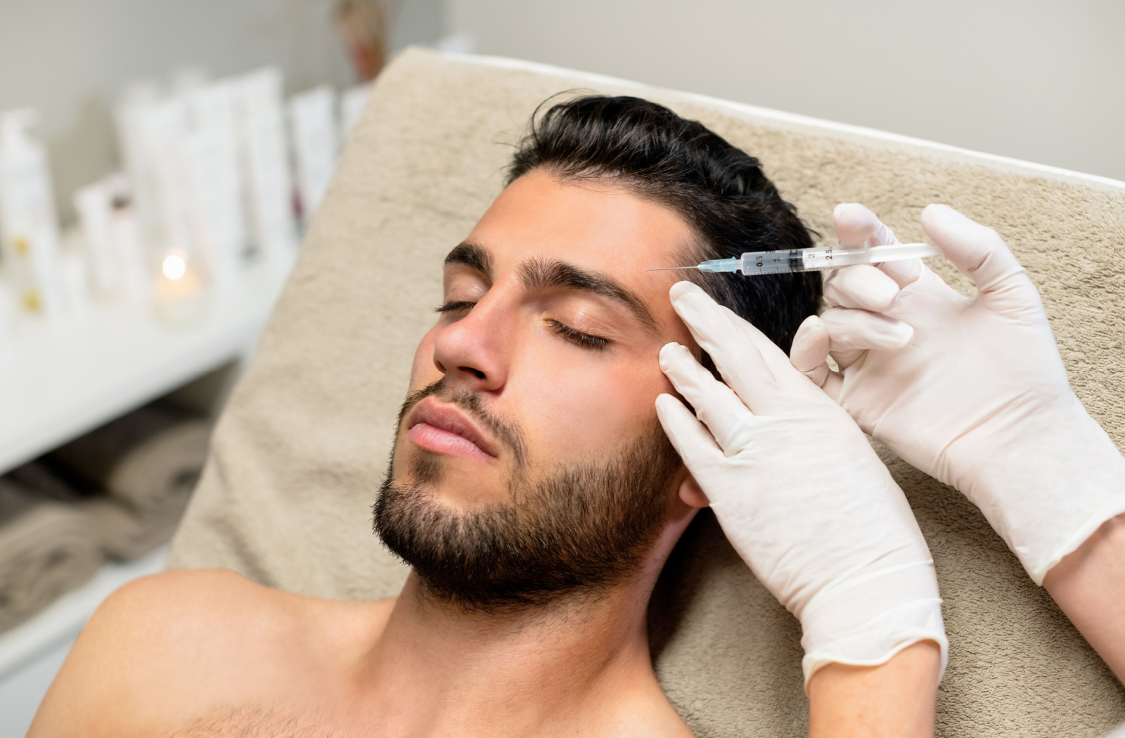 A man getting botox injected into the forehead area. 