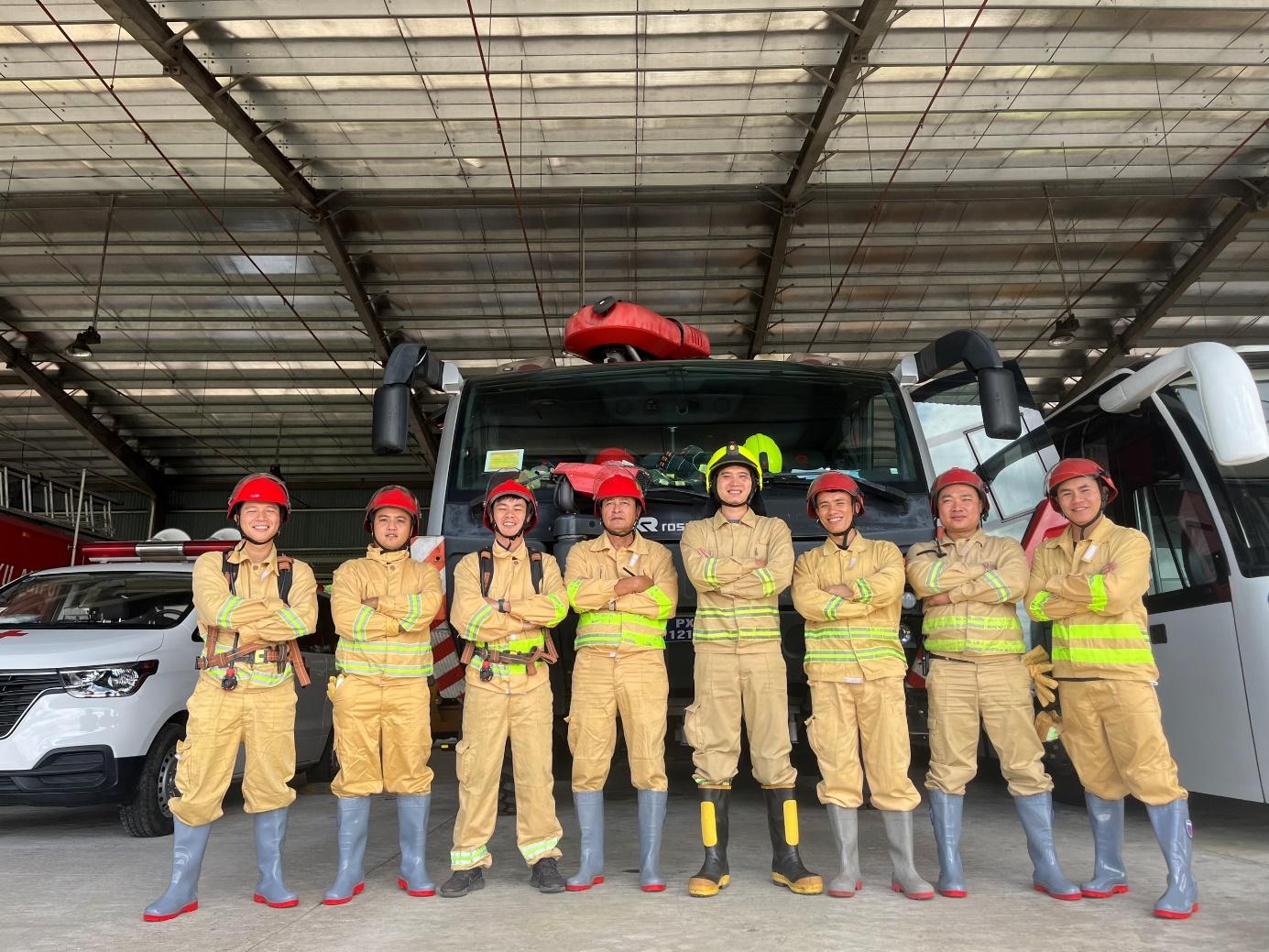 A group of people in uniform standing in front of a truckDescription automatically generated