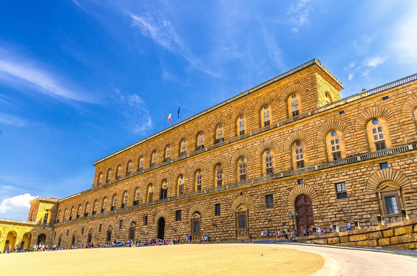 A large building with many windows with Palazzo Pitti in the background

Description automatically generated