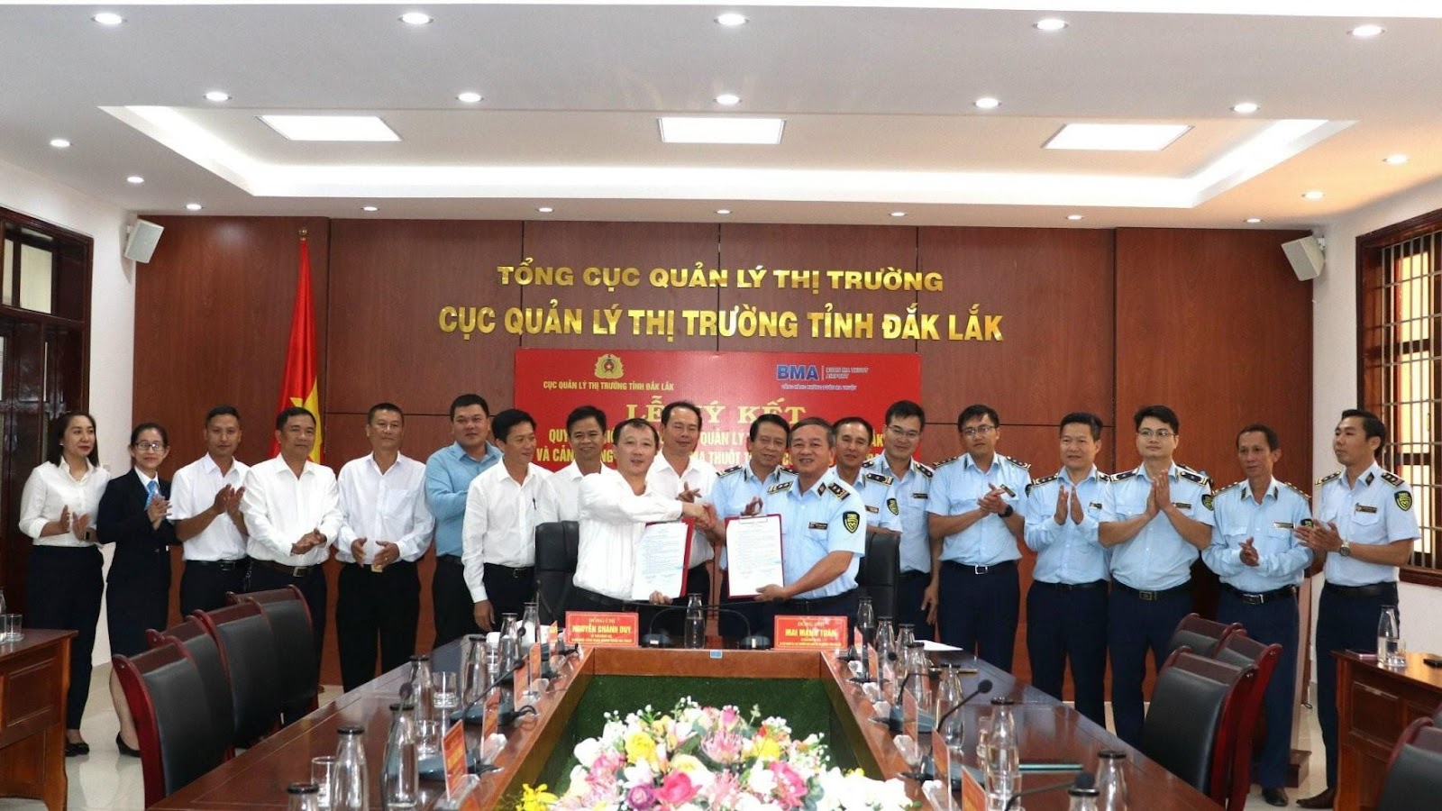 A group of people in uniform standing in front of a tableDescription automatically generated