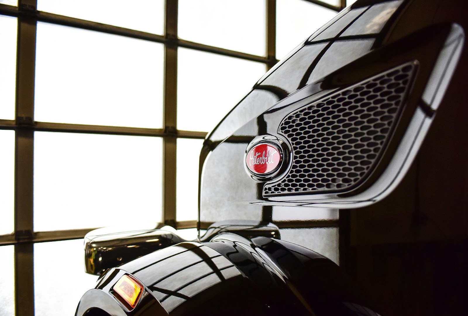 A close-up picture of the Peterbilt insignia on a black truck grill