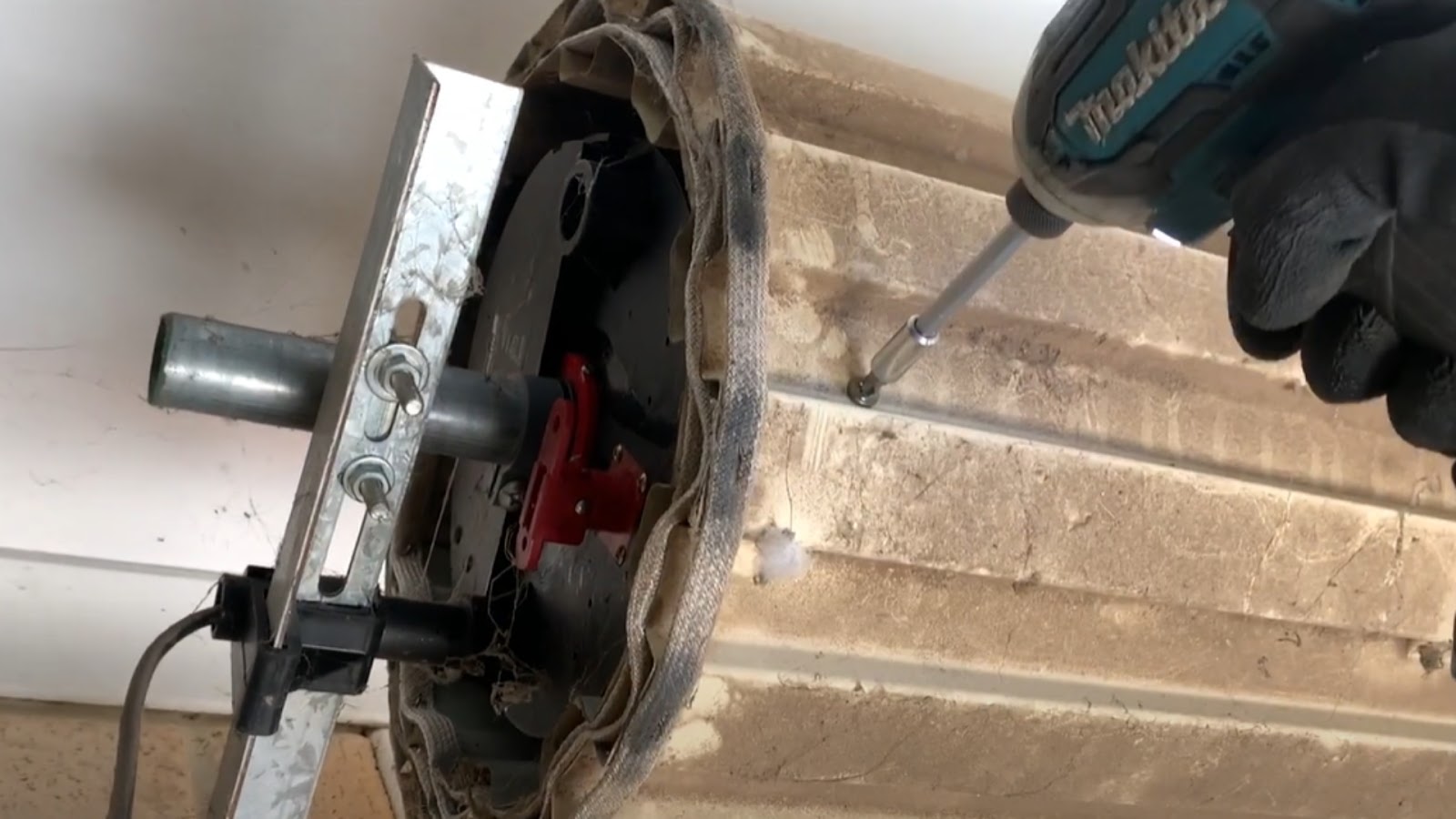 A technician tightening the screws of a garage roller door