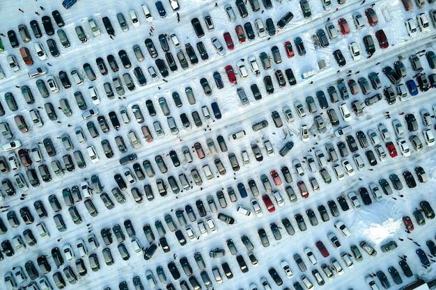 Photo aerial view of many cars parked for sale and people customers walking on car market or parking lot in winter