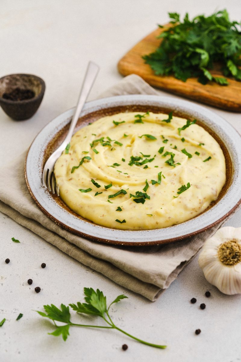 Red skin mashed potatoes with parsley and garlic on a plate.