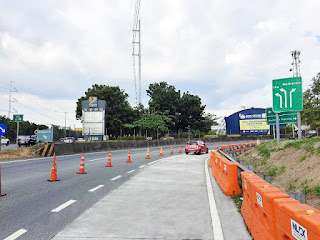 A road with traffic cones and signs

Description automatically generated