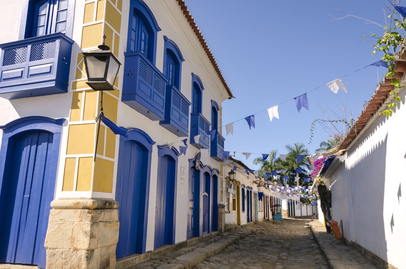 Rua histórica de Paraty com casas coloniais brancas com portas e janelas em azul