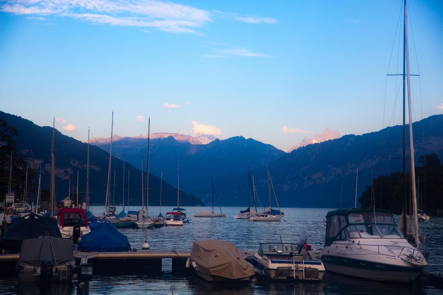 Boats on the water with mountains in the background

Description automatically generated