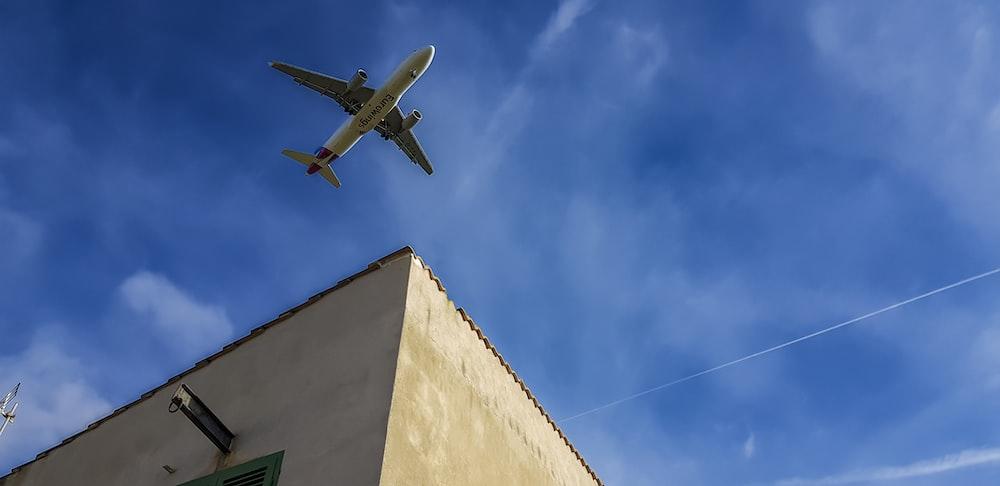 an airplane is flying over a building