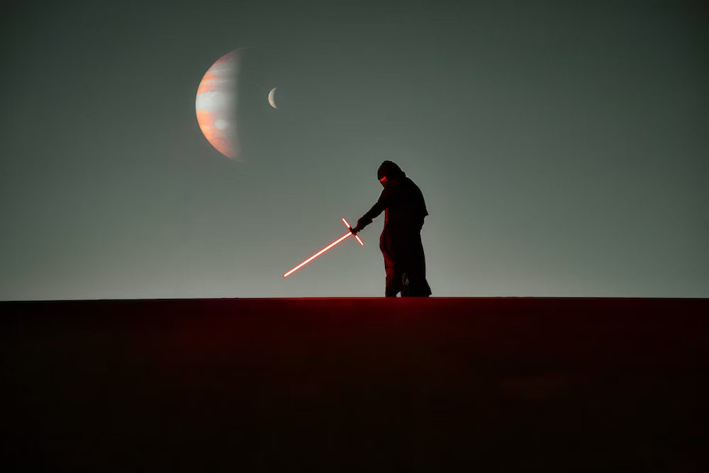 Star Wars Character With Lightsaber in Hand and Moon in the Background