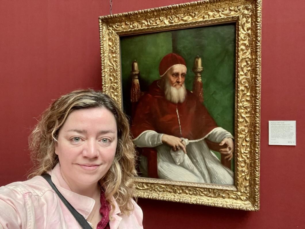 A person taking a selfie in front of a painting

Description automatically generated