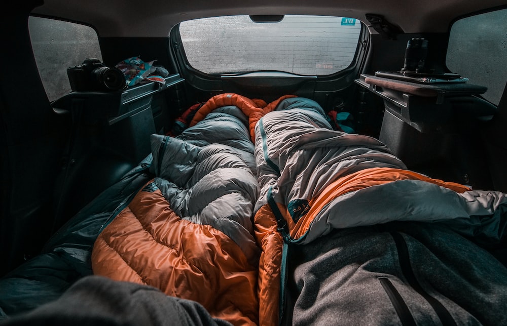 Schwarzer und orangefarbener Rucksack auf dem Autositz