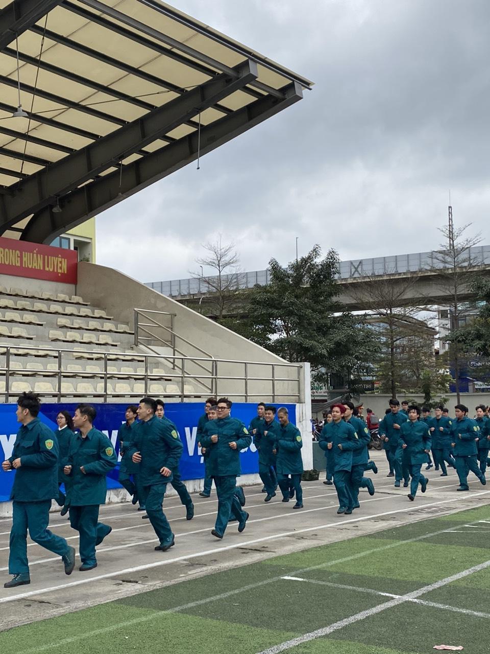 A group of people in blue uniforms running on a field

Description automatically generated