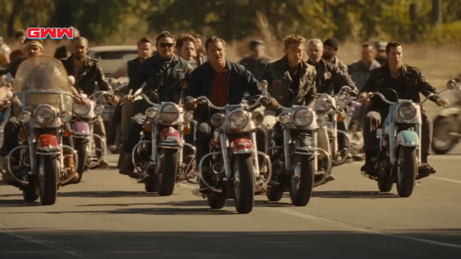 A group of bikers riding motorcycles on a road together.