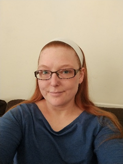 picture of Rosie - rosie has long red hair and is wearing glasses 
smiling